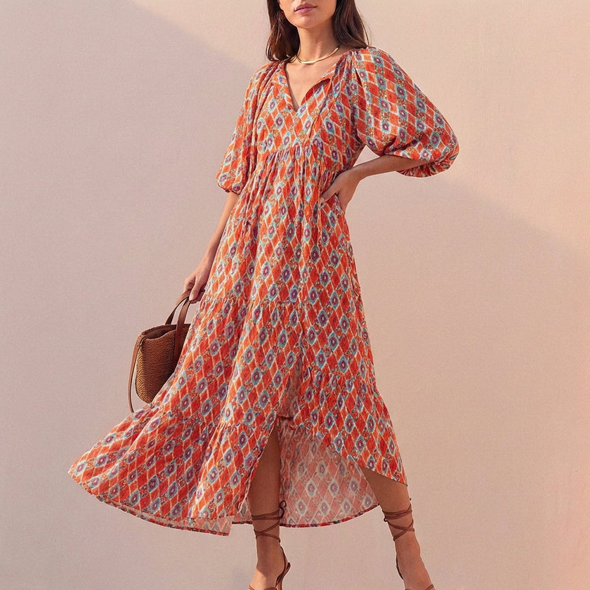 Orange FJØRNA women's elegant maxi dress with V-neck and puff sleeves, flowing style perfect for stylish occasions.