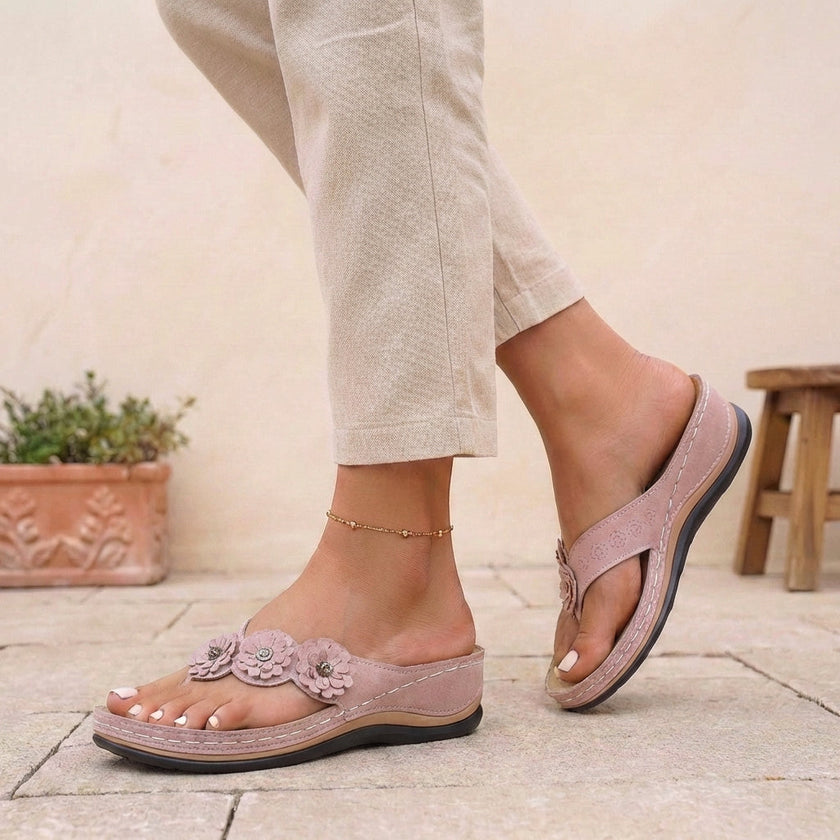 Pink FJØRNA orthopedic open toe wedge flip-flops with floral embellishments, featuring cushioned soles and stylish summer design.