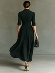 FJØRNA pleated maxi dress for women with flowing fabric and elegant design, shown on a model.