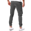 FJØRNA men's durable cargo pants with multiple pockets, suitable for outdoor and urban activities, shown in a rugged outdoor setting.