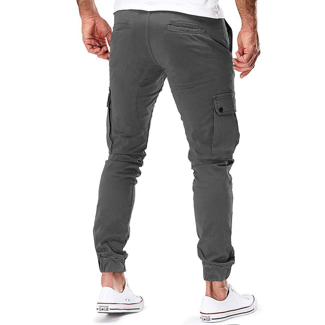 FJØRNA men's durable cargo pants with multiple pockets, suitable for outdoor and urban activities, shown in a rugged outdoor setting.
