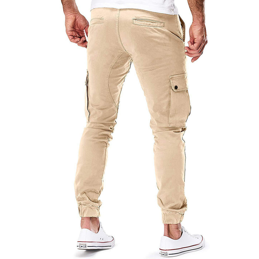 FJØRNA men's durable cargo pants with multiple pockets, suitable for outdoor and urban wear, shown in a rugged outdoor setting.