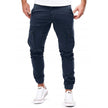FJØRNA men's durable cargo pants with multiple pockets, suitable for outdoor and urban wear, shown in rugged outdoor setting.