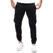 Durable men's cargo pants by FJØRNA with multiple pockets, suitable for outdoor and urban wear, shown in a rugged outdoor setting.