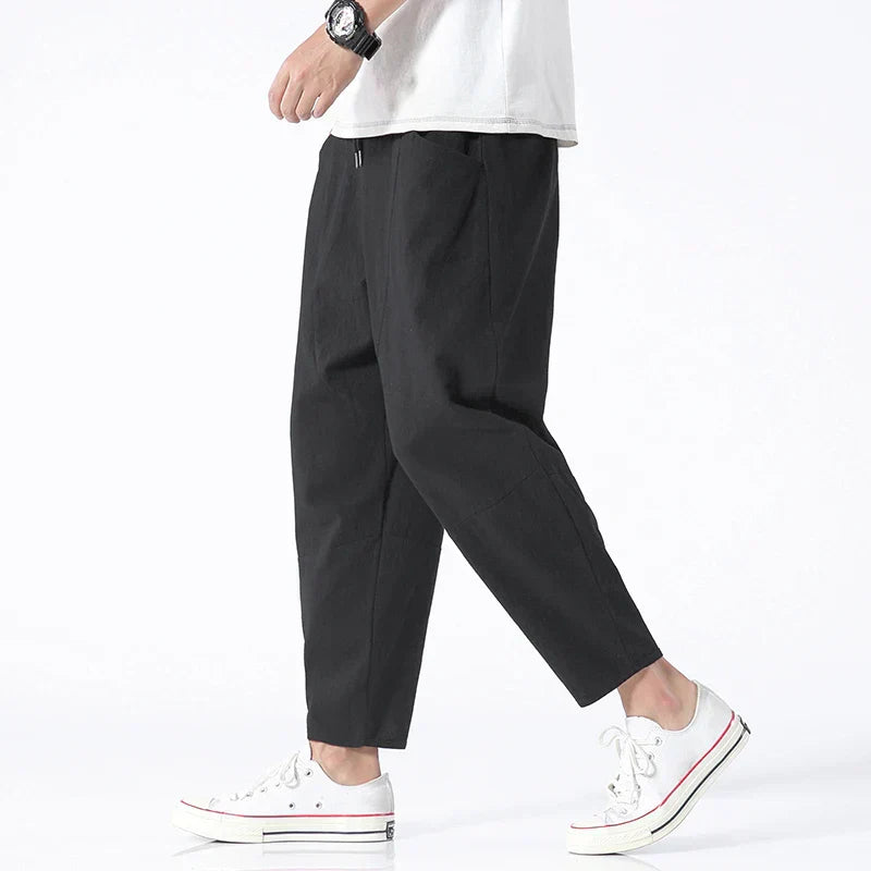 Men's cropped linen trousers in indigo by FJØRNA, featuring a relaxed fit and lightweight fabric for casual style.