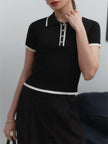 Black cotton polo top for women by FJØRNA, casual short-sleeve polo shirt with a classic collar and button detail.