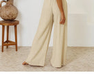 FJØRNA linen wide-leg trousers for women, loose pull-on pants with a relaxed fit and wide-leg design, shown in natural fabric.