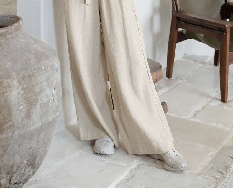 Light beige linen wide-leg trousers for women by FJØRNA, featuring loose pull-on style and relaxed fit.