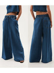 Blue denim wide-leg drawstring jeans for women by FJØRNA, relaxed fit with casual style, shown on a model.
