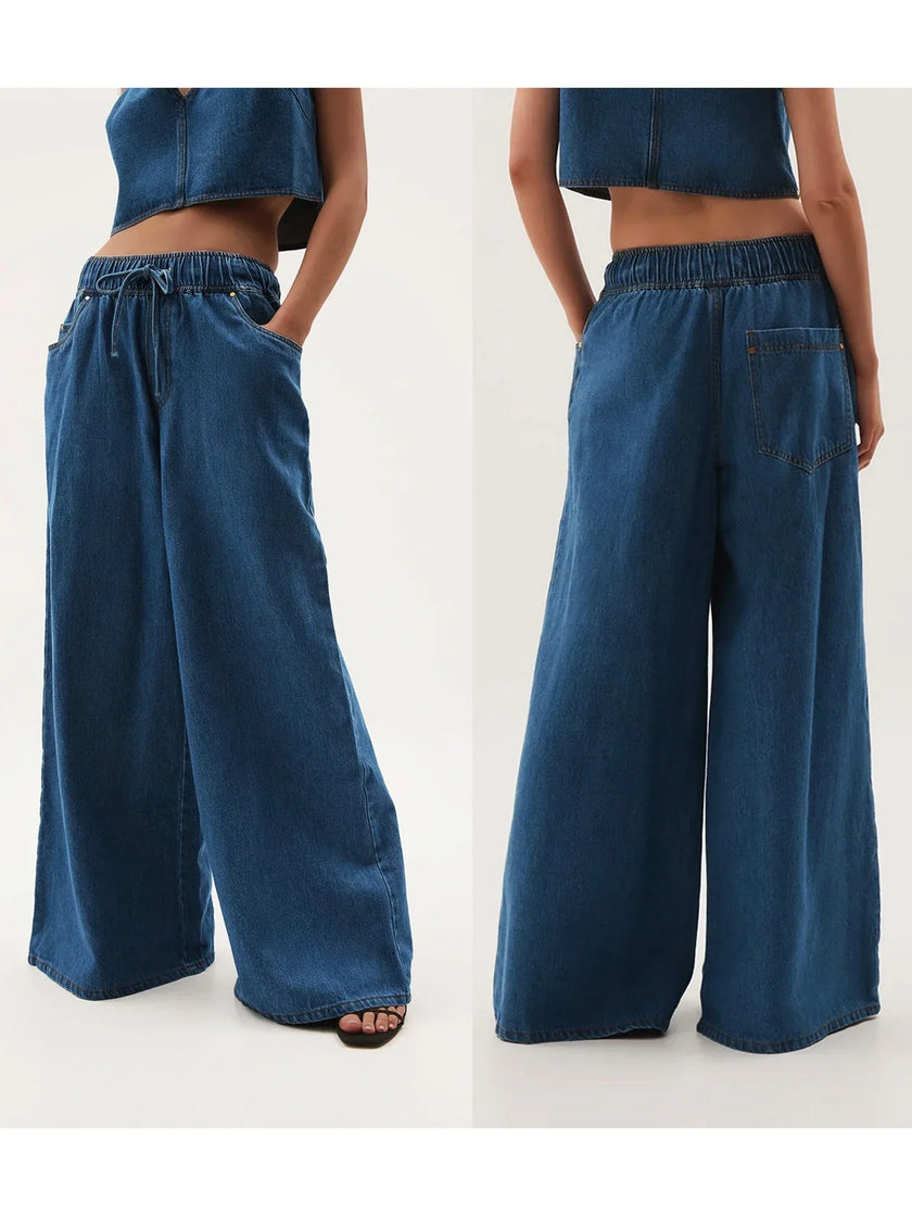 Blue denim wide-leg drawstring jeans for women by FJØRNA, relaxed fit with casual style, shown on a model.