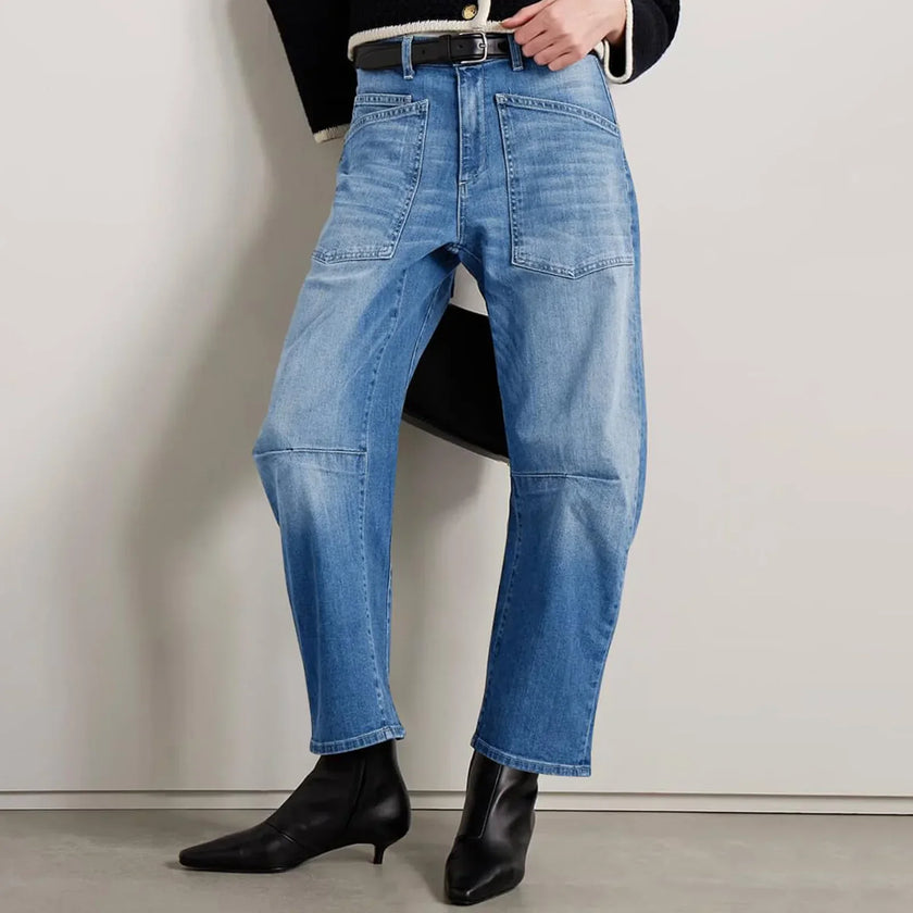 FJØRNA women's denim jeans with barrel leg style, showcasing classic blue pants with a relaxed fit and modern silhouette.