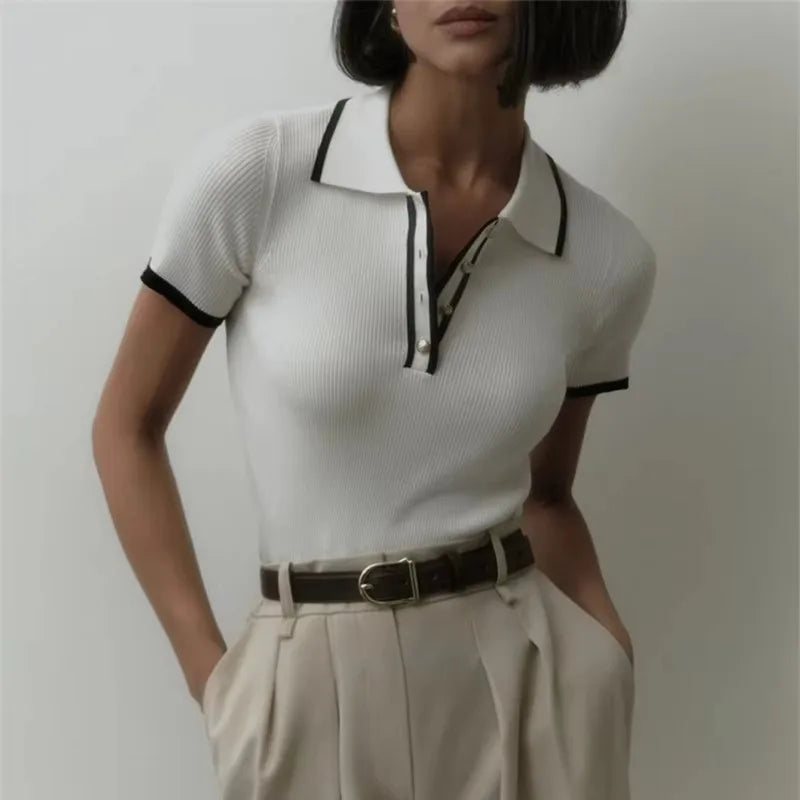 Black FJØRNA cotton polo top for women, stylish short-sleeve polo shirt with classic collar and fitted design.