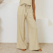Light beige linen wide-leg trousers for women by FJØRNA, featuring a loose pull-on style and relaxed fit.