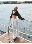 FJØRNA women's knit wide-leg trousers with drawstring waist, soft fabric, and relaxed fit, shown in a neutral color.