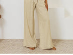 FJØRNA linen wide-leg women's trousers, loose pull-on pants with a relaxed fit and natural fabric texture.