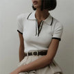 Black FJØRNA cotton polo top for women, women's short-sleeve polo shirt with classic collar and button closure.
