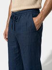 Men's linen trousers by FJØRNA with relaxed fit, breathable fabric, ideal for summer, shown in a close-up shot.