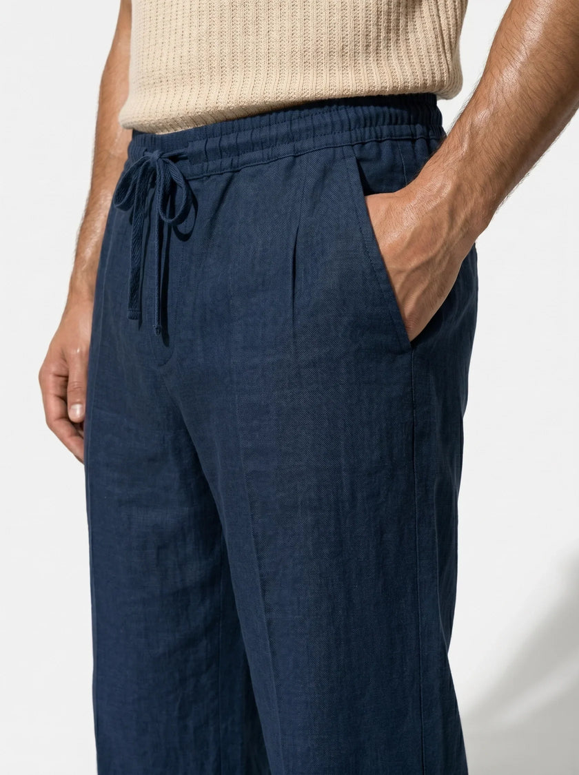 Men's linen trousers by FJØRNA with relaxed fit, breathable fabric, ideal for summer, shown in a close-up shot.