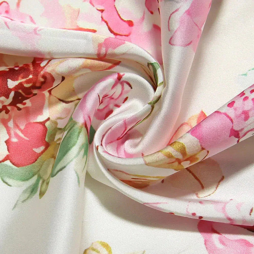 White satin floral pencil maxi dress by FJØRNA with a fitted silhouette and elegant floral pattern.