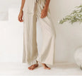 FJØRNA linen wide-leg trousers for women, loose pull-on pants with a relaxed fit and flowy silhouette, shown on a model.
