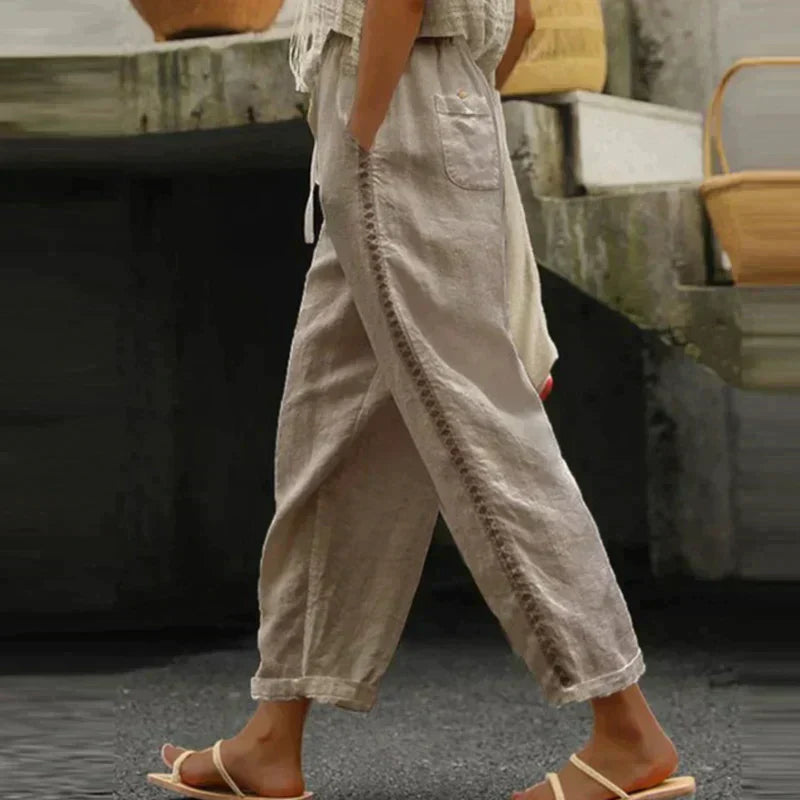 FJØRNA linen summer trousers for women, high waist tapered fit, light and breathable fabric, shown in a relaxed fit.