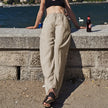 FJØRNA women's knit wide-leg trousers with drawstring waist, featuring a relaxed fit and soft fabric, shown in a neutral color.