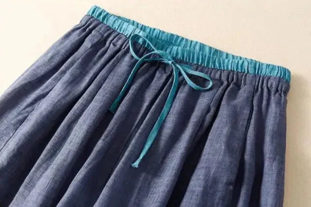 FJØRNA women's linen tapered trousers displayed flat, showing lightweight, breathable fabric and relaxed fit for casual wear.
