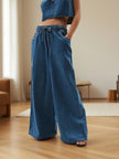 Blue FJØRNA women's denim wide-leg pants with drawstring waist, relaxed fit, and stylish casual design.