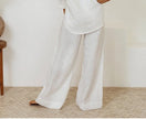 FJØRNA linen wide-leg women's trousers with a loose fit, pull-on style, and relaxed silhouette in a light, breathable fabric.