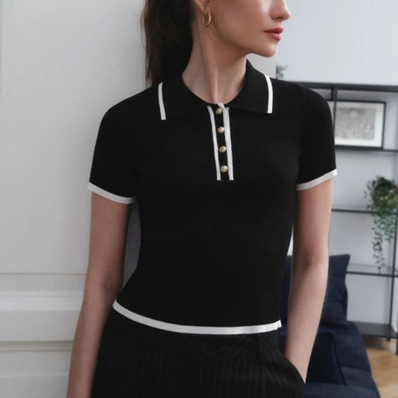 Black FJØRNA cotton polo top for women, classic short-sleeve polo shirt with a collared neckline and button details.