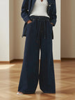 Blue denim wide-leg drawstring women's jeans by FJØRNA featuring relaxed fit and casual style.