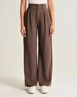White wide-leg high-waist trousers for women by FJØRNA, featuring a relaxed fit and tailored high-rise design.