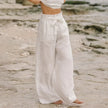 FJØRNA linen wide-leg trousers for women, loose pull-on pants with a relaxed fit and natural fabric, shown on a model's legs.