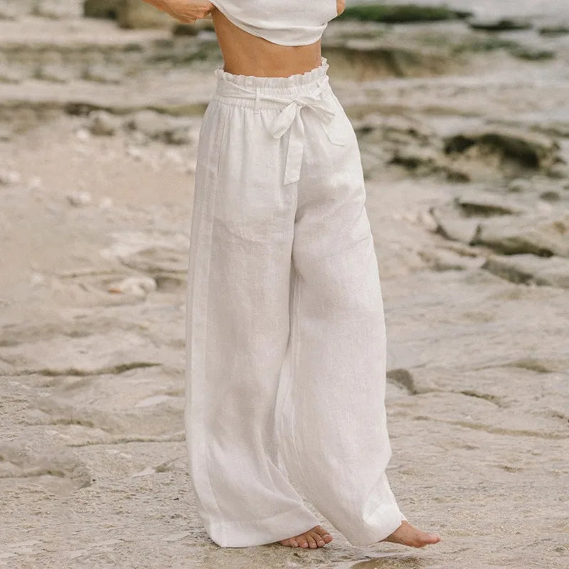 FJØRNA linen wide-leg trousers for women, loose pull-on pants with a relaxed fit and natural fabric, shown on a model's legs.