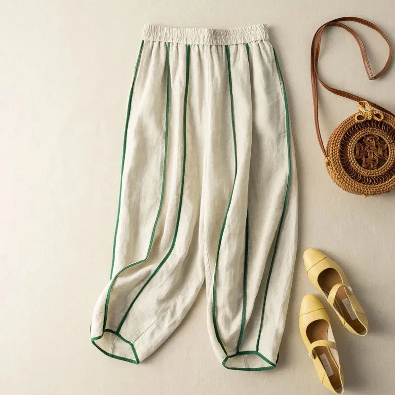 FJØRNA linen wide-leg women's trousers with elastic waistband, showing relaxed fit and lightweight fabric in a neutral color.