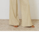 FJØRNA linen wide-leg trousers for women, loose pull-on pants with relaxed fit and natural linen fabric, shown in a neutral color.