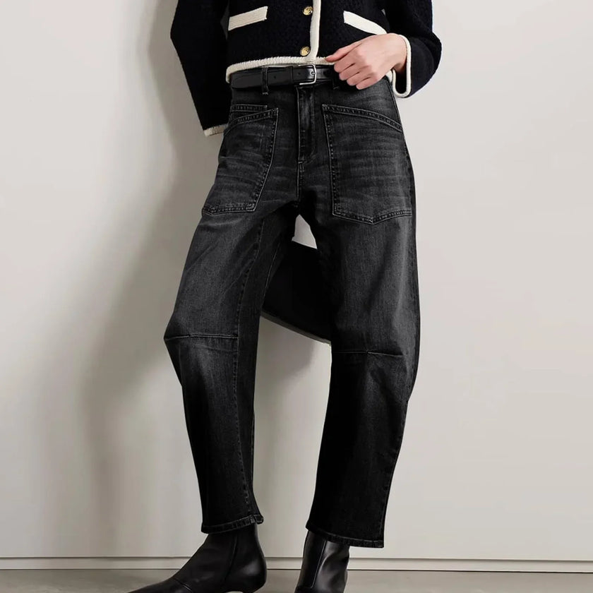 FJØRNA women's denim jeans with a barrel leg fit, showcasing classic blue denim with a relaxed, stylish silhouette.