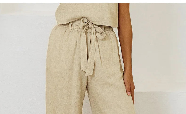 FJØRNA linen wide-leg women's pants with a loose fit and pull-on design, shown in a relaxed, comfortable style.