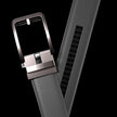 Gray vegan leather ratchet belt by FJØRNA, adjustable unisex belt with sleek modern design and metal buckle for versatile wear.