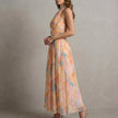 FJØRNA elegant women's maxi dress with halter neck and flowy fabric, shown from the side view.