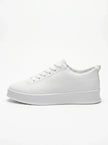 FJØRNA white men's slip-on trainers with a clean, minimalist design shown from the side profile. Casual shoe for everyday wear.