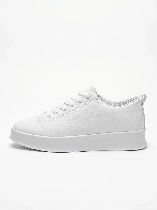 FJØRNA white men's slip-on trainers with a clean, minimalist design shown from the side profile. Casual shoe for everyday wear.