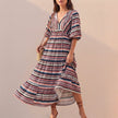 FJØRNA elegant women's maxi dress with V-neck and puff sleeves featuring a stylish striped pattern, perfect for sophisticated occasions.