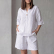 White FJØRNA women's two-piece co-ord set with V-neck top, lightweight fabric, and pockets, perfect for casual wear.