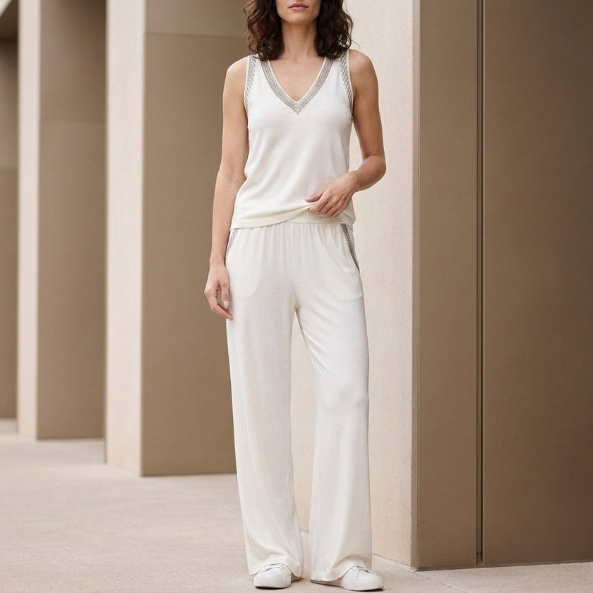 White women's summer two-piece set with wide-leg pants and V-neck top by FJØRNA, perfect for warm weather.