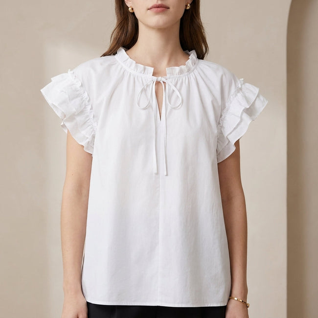 White FJØRNA summer blouse for women with cap sleeves and ruffle detail, perfect for warm weather and casual outings.
