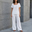 White summer two-piece women's co-ord set by FJØRNA featuring relaxed fit wide-leg pants and matching top.