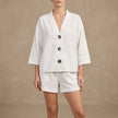 White women's summer two-piece co-ord set by FJØRNA with button front V-neck top and matching shorts.