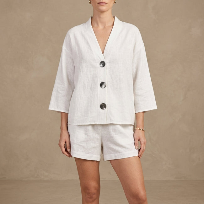 White women's summer two-piece co-ord set by FJØRNA with button front V-neck top and matching shorts.