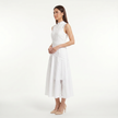 Side profile of FJØRNA women's white sleeveless lace panel midi dress showing intricate lace details and elegant silhouette.